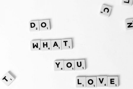 Scrabble tiles spelling 'Do What You Love' on a white background, encouraging creativity.