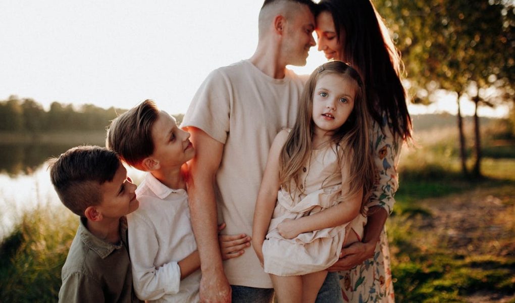 Family enjoying quality time together outdoors by the lake during sunset.